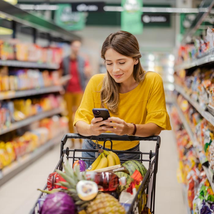 woman using phone in grocery store
